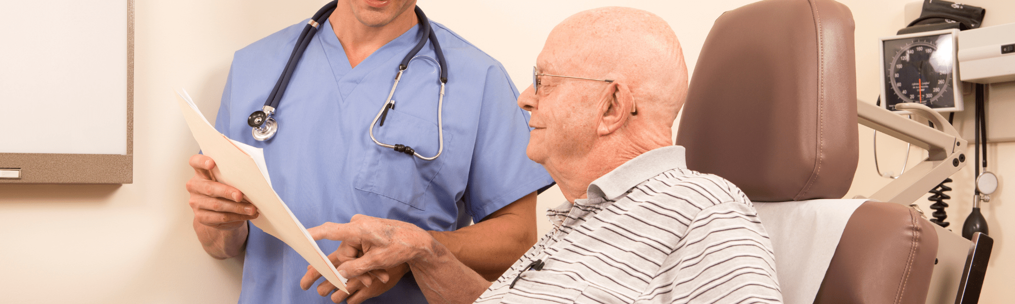 elderly man at the doctor reviewing paperwork 
