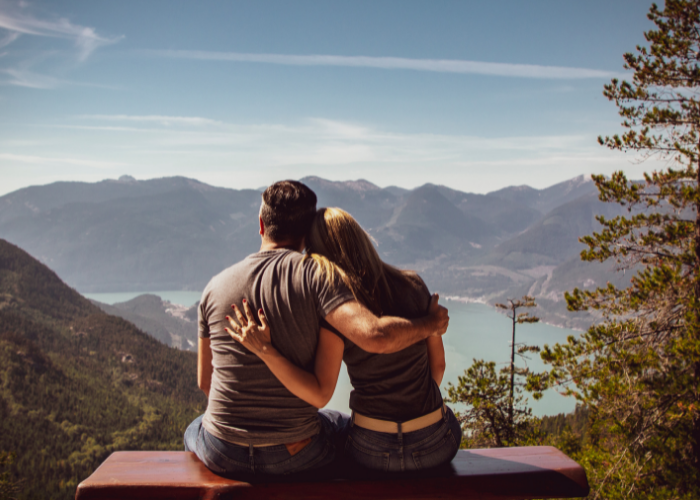 couple on a bench overlooking a mountain view
