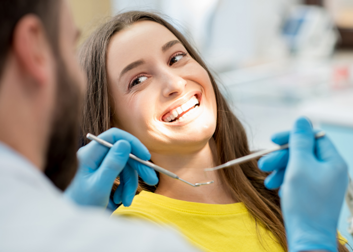 woman having teeth cleaned and examined by a dentist 